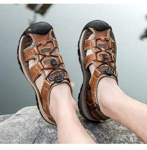 Dettaglio dei sandali outdoor in pelle marrone con punta in gomma e lacci rapidi