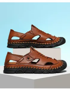 Detailed view of hand-stitched leather upper and protective rubber toe on brown sandals
