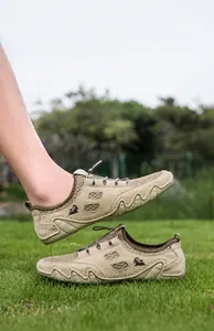 Détail de baskets en mesh kaki avec semelle crantée ondulée sur de l'herbe