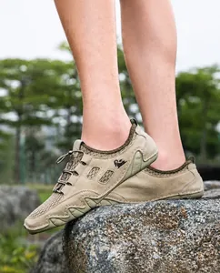 Détail des chaussures d'extérieur kaki pour hommes en mesh respirant sur un rocher