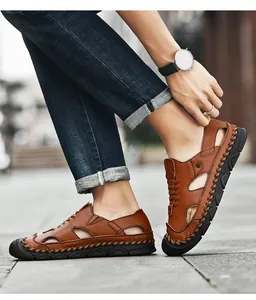 Close-up of men's brown leather beach sandals with handmade stitching and breathable cutouts