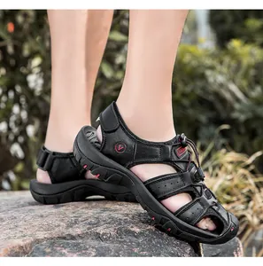 Dettaglio dei sandali outdoor in pelle nera con suola in gomma antiscivolo sulle rocce