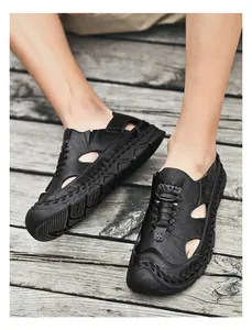 Detailed top view of black leather sandals with breathable hollow cutouts and stitched edges