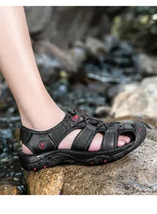 Dettaglio delle scarpe da scoglio da uomo antiscivolo su rocce bagnate in un ruscello