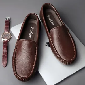 Klassische braune Leder-Loafer für Herren und Uhr auf einem Schreibtisch platziert