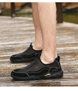 Gros plan de baskets noires en mesh respirant pour hommes avec logo SPORT sur bois