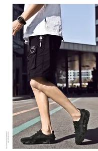 Details von schwarzen Herren-Mesh-Sneakern mit gelbem Stern und passenden Cargo-Shorts