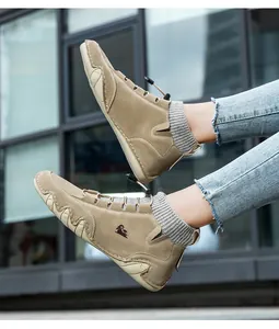 Outdoor shot of khaki suede loafers with ram logo and wave-patterned rubber soles