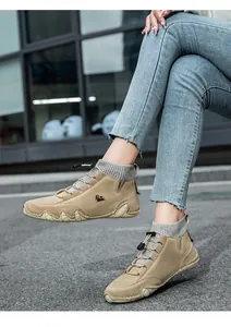 Close-up of khaki nubuck high-top outdoor boots with grey knitted socks and elastic laces
