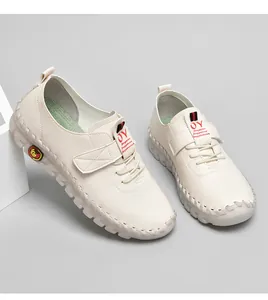 Détail de chaussures plates beiges en cuir avec lacets élastiques et texture grainée