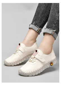 Détail de couture faite main sur mocassins en cuir beige avec semelle en caoutchouc