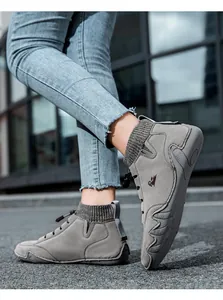 Gray suede high-top boots with knit sock collar and durable rubber sole on city street