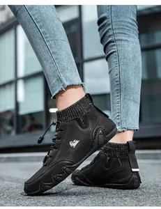 Close-up of black leather and knit high-top sneakers with drawstring laces on city street