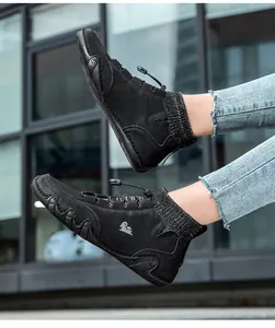 Detail of black high-top sock boots with outdoor rubber sole and white ram logo