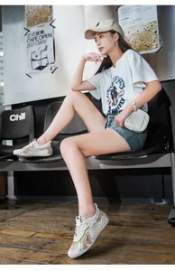Dettaglio di scarpe sportive in mesh traspirante con patchwork tricolore e logo DBECI