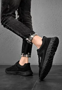 Dettaglio di sneaker in rete nera con scritta FREEDOM e suola in gomma spessa