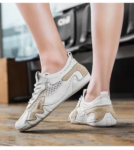 Dettaglio di sneaker in mesh bianco con inserti in pelle kaki e scritte DBECI