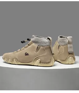 Detail of khaki suede boots featuring knit collar, elastic laces, and textured rubber sole