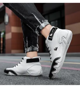 Close-up of white leather high-top sneakers with black straps and side wave detailing
