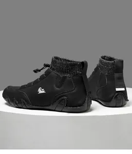 Detail of men's black leather high-top boots with knit sock cuff and mountain goat logo