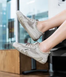 Dettaglio di sneakers in mesh beige traspirante con logo laterale e suola in gomma flessibile