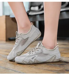 Dettaglio di scarpe da corsa in mesh grigio con inserti in pelle scamosciata e logo