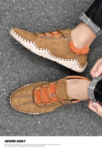 Detail van handgemaakte bruine vrijetijdsschoenen met oranje corduroy en contraststiksels