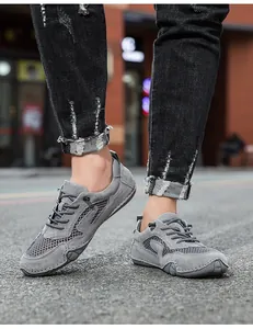 Detailopname van grijze ademende mesh sneakers voor heren met stevige rubberen zolen