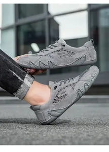 Detail van grijze mesh sneakers met suède panelen en antislip rubberen buitenzolen