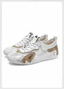 Dettaglio di sneaker in mesh bianco traspirante con accenti in pelle marrone e logo DBECI