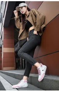 Detailed side view of white and pink high-top fashion sneakers worn in street style
