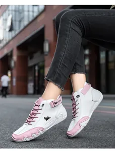 Detail of pink velcro strap and lace-up design on stylish high-top white sneakers