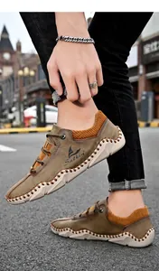 On-foot beeld van casual kaki suède schoenen met oranje ribbels en wit handstiksel