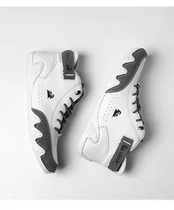 Detailed top view of high-top sneakers in white and grey leather with velcro strap