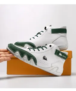 Detail of high-top leather boots in white and green with a side ram logo and velcro strap