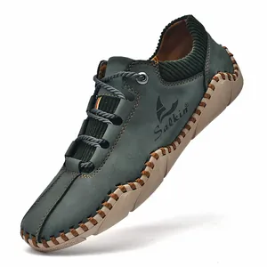 Detail van de handgemaakte stiksels en groen suède op deze casual leren herenschoenen