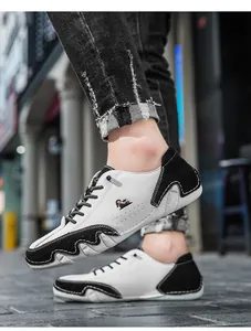 Detail view of stylish black and white low-top casual sneakers in an outdoor street setting