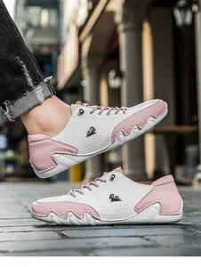Detail of pink and white low-top sneakers featuring contrast panels and wavy textured soles