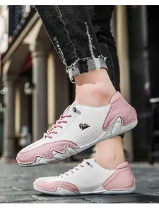 Macro view of pink and white leather casual sneakers with unique wavy rubber sole