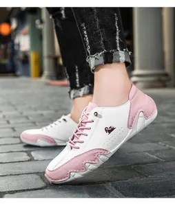 Close-up of pink and white paneled casual shoes with ram logo and breathable perforations