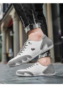 Detail of grey and white casual sneakers featuring octopus-style non-slip sole and logo