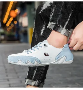 Close-up of low-top sneakers featuring blue and white leather patchwork and sheep logo