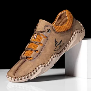 Detail of handmade stitching and orange corduroy lining on brown suede casual shoe