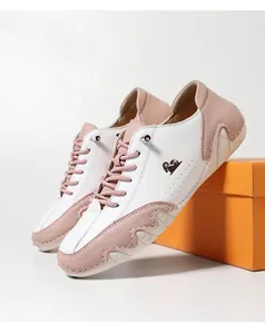 Detail of pink and white low-top casual shoes featuring a distinct black ram head logo