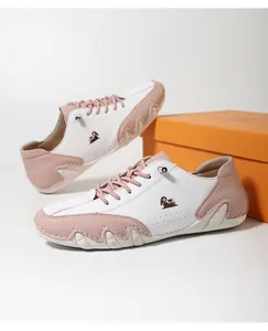 Detail of pink and white pebbled leather sneakers with goat logo and wavy stitching