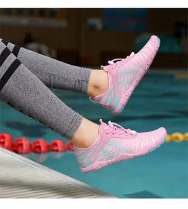 Detail von rosa-blauen Barfußschuhen am Poolrand mit rutschfester Gummisohle für Damen