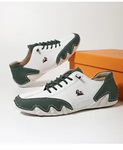 Detail of white and dark green leather sneaker featuring wave-patterned sole and logo