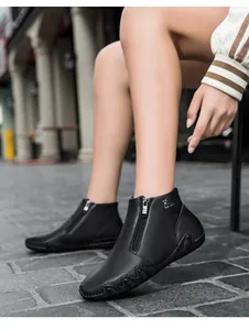 Close-up of black leather ankle boots featuring a side zipper and reindeer logo detail