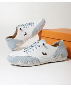 Detail view of stylish low-top leather shoes in blue and white with wave-textured soles