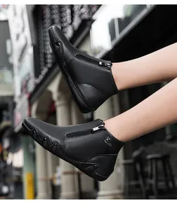 Detail view of black leather boots with side zipper and durable rubber outsole